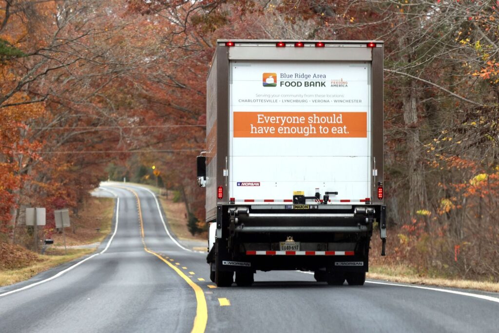Mobile Food Pantry truck with "Everyone should have enough to eat." emblazoned on its back. It drives down a country highway.