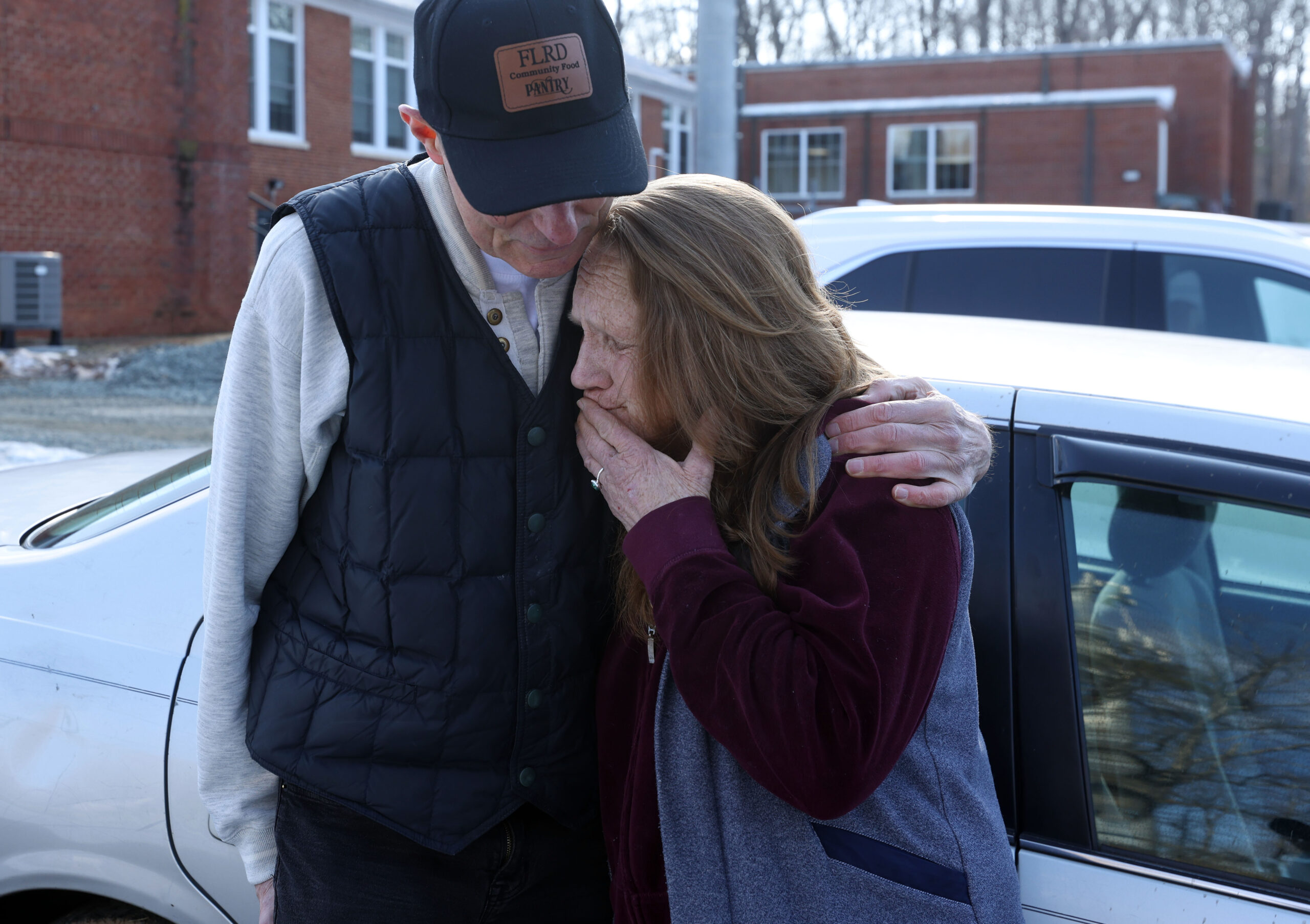 A volunteer at Fluvanna Leaders for Race and Diversity food pantry holds a guest during a recent distribution. 