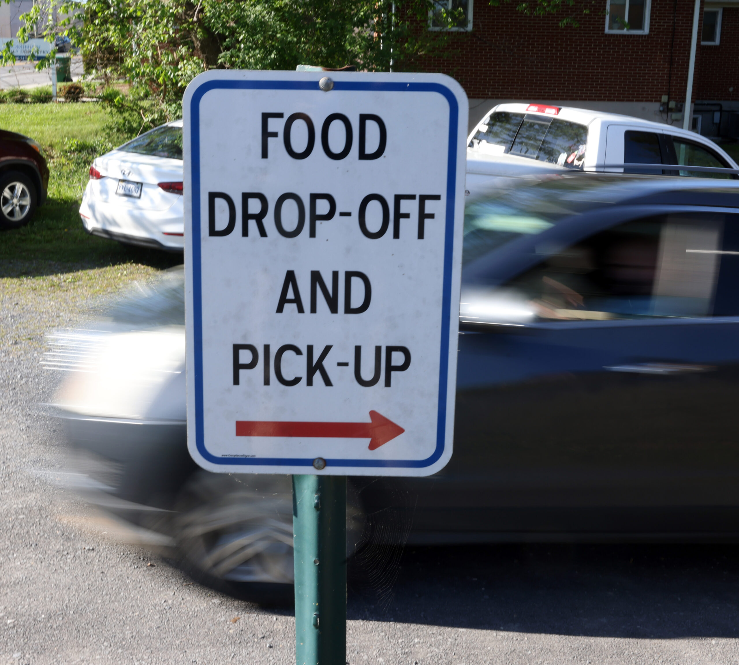 A sign in front of the food pantry directs guests where to go for food drop-off and pick-up.